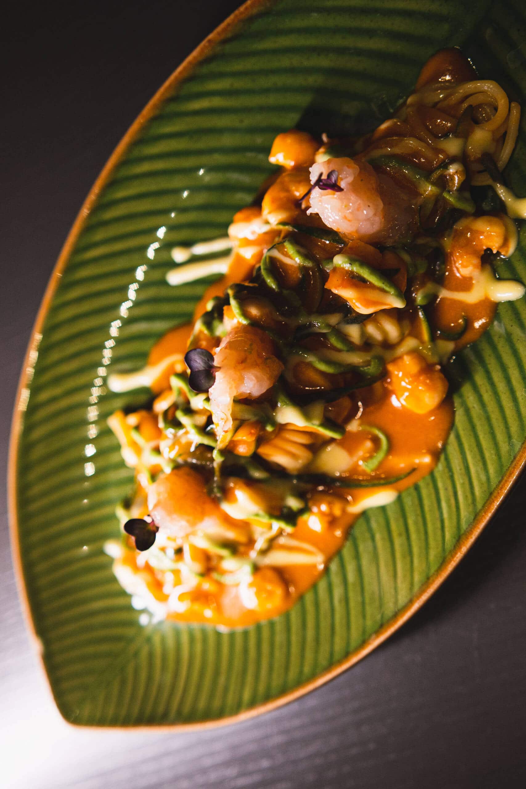 Piatti di sushi e pesce con verdure e salsa.