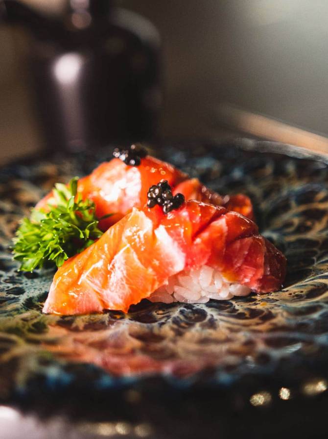 Sushi con salmone, tonno e caviale su piatto elegante.